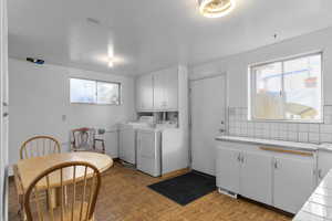 Laundry area featuring cabinet space, baseboards, visible vents, and washer and clothes dryer