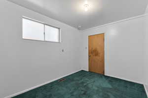 Carpeted spare room featuring visible vents and baseboards