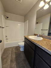 Bathroom featuring visible vents, toilet, a textured ceiling, shower / tub combination, and vanity