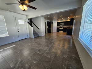 Unfurnished living room featuring a healthy amount of sunlight, baseboards, stairs, and visible vents