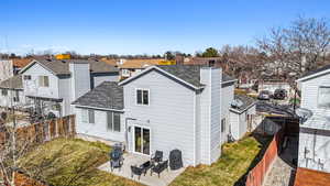 Back of house featuring a patio, a shingled roof, a fenced backyard, and a residential view