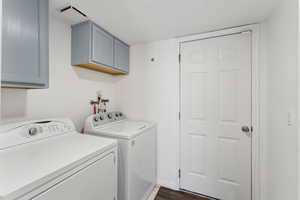 Clothes washing area featuring cabinet space, visible vents, baseboards, dark wood-style floors, and washing machine and dryer