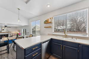 Kitchen featuring light countertops, a sink, a peninsula, and stainless steel dishwasher