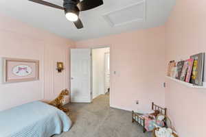 Bedroom featuring baseboards, a ceiling fan, attic access, and light colored carpet