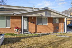 View of front facade featuring brick siding, a front lawn, and roof with shingles