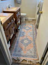 Full bathroom featuring visible vents, toilet, decorative backsplash, vanity, and baseboards