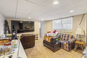 Living area with recessed lighting, carpet flooring, and a drop ceiling