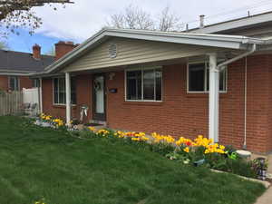 View of front of home with a front lawn, fence, and brick siding