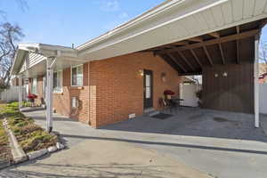 View of side of property featuring fence and brick siding