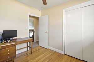 Office space with light wood-type flooring, baseboards, and a ceiling fan