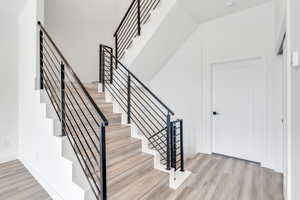 Stairway with baseboards and wood finished floors