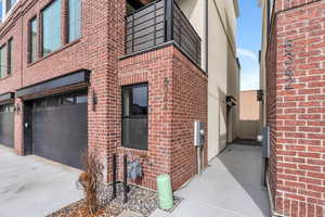 Exterior space featuring driveway, a garage, and brick siding