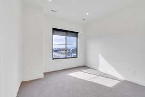 Unfurnished room featuring light carpet, baseboards, visible vents, and recessed lighting