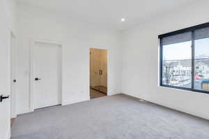 Unfurnished bedroom featuring carpet, ensuite bathroom, baseboards, and recessed lighting