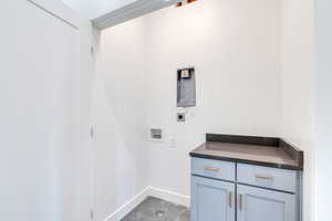 Laundry room featuring hookup for a washing machine, hookup for an electric dryer, cabinet space, and baseboards