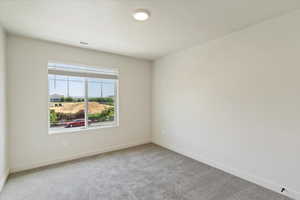 Carpeted spare room featuring baseboards