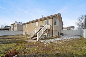 Back of house with a fenced backyard and central AC unit