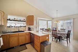 Kitchen featuring visible vents, dishwasher, a peninsula, light countertops, and a sink