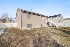 Rear view of house featuring stairway, a fenced backyard, and a gate