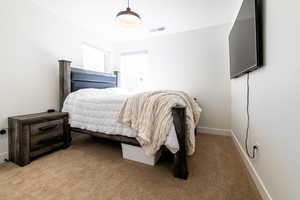 Bedroom featuring baseboards, visible vents, and light colored carpet