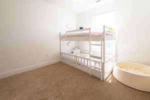 Carpeted bedroom featuring baseboards and visible vents