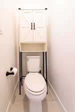 Bathroom featuring tile patterned flooring, toilet, and baseboards