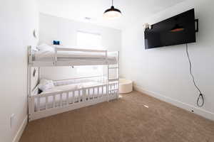 Unfurnished bedroom with carpet flooring, visible vents, and baseboards