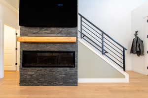 Details featuring a fireplace, baseboards, and wood finished floors