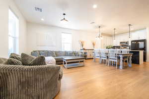 Living room featuring light wood finished floors, visible vents, and recessed lighting