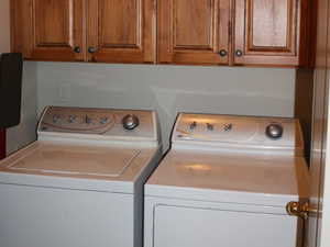 Laundry area featuring cabinet space and washer and clothes dryer