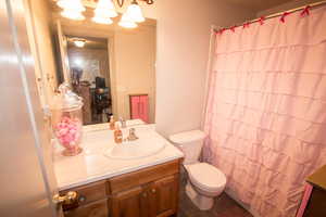 Bathroom with a shower with shower curtain, vanity, and toilet