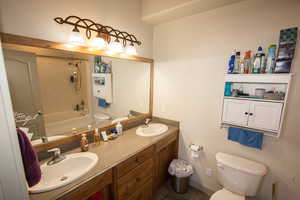 Bathroom featuring double vanity, a sink, and toilet