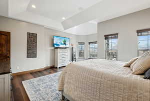 Bedroom featuring a tray ceiling and dark hardwood / wood-style floors