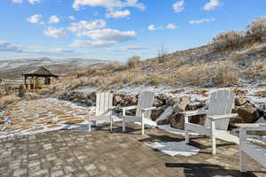 Snow covered patio featuring a mountain view and a gazebo