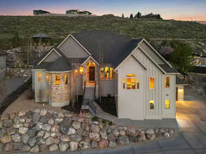 View of front facade featuring board and batten siding, driveway, and stone siding