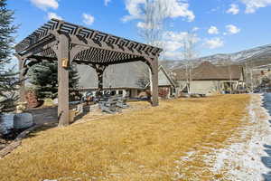 View of yard with a mountain view and a pergola