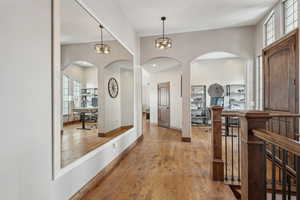 Hall featuring a healthy amount of sunlight and light hardwood / wood-style flooring