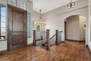 Entryway with dark hardwood / wood-style flooring, a wealth of natural light, and a chandelier