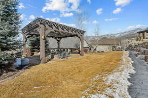 View of yard with a mountain view and a pergola