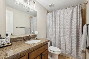 Bathroom featuring vanity, toilet, and walk in shower