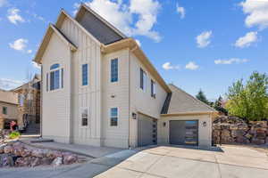 View of front of property with board and batten siding and concrete driveway