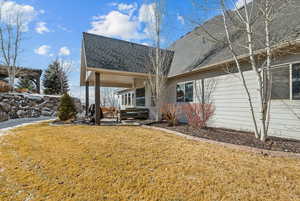 Back of house with a yard and a patio