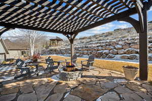 Snow covered patio with a pergola, a gazebo, and an outdoor fire pit