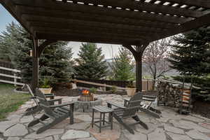 View of patio with fence, a pergola, and a fire pit