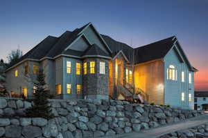 View of front of house with board and batten siding, stairway, and stone siding
