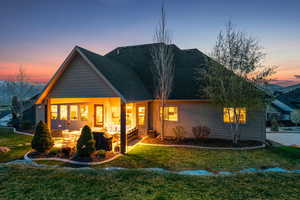 Rear view of house featuring a lawn and a shingled roof