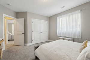 Bedroom featuring light colored carpet and a closet