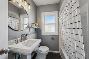 Bathroom with toilet, baseboards, and a sink