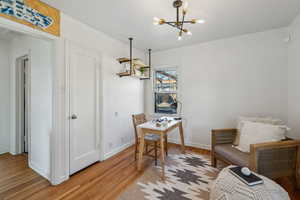 Interior space featuring baseboards, a chandelier, and wood finished floors