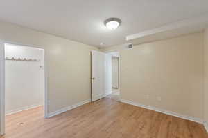 Unfurnished room with light wood-style floors, visible vents, and baseboards